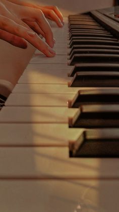 two hands are playing the piano with their fingers