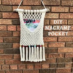 a crocheted macrame hanging on a brick wall with the words diy macrame pocket