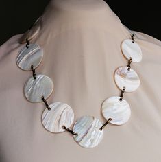 Vintage Hawaii necklace with large mother of pearl polished white shells linked with brass loops. Fine example of boho chic tourist souvenir jewelry from the 1960s-70s. Set with 14 large shell discs. Neclace length is 70 cms. Shells are 4 cms wide in diameter. Rare! Suitable as a fine vintage gift for her into luxury boho hippie chic jewelry. Pre-owned, in a good used condition. Shiny beautiful mother of pearl discs. Somewhat darkened brass metal. (May of course be polished with metal polish). W Luxury Handmade Mother Of Pearl Shell Necklace, Handmade Vintage Shell Necklace, Handmade Shell-shaped Mother Of Pearl Necklaces, Mother Of Pearl Shell-shaped Necklace For The Beach, Hippie Chic Jewelry, Hawaii Necklace, Vintage Shell-shaped Necklaces For Gifts, Souvenir Jewelry, Boho Hippie Chic