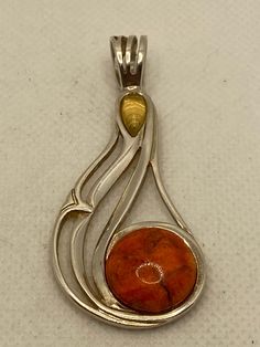 "This is a vintage, genuine, gorgeous, rare Jay King multi stone and sterling silver pendant with genuine yellow citrine and orange sponge coral. The pendant is large, measuring about 2 1/3\" by 1 1/8\". The bale opening is about 1/2\" in diameter. The orange sponge coral is round-cut and set in a polished sterling silver bezel. It measures about 5/8\" in diameter. The teardrop-cut yellow citrine is also set in a polished sterling silver bezel and measures about 3/8\" by 1/4\" at the widest poin Orange Polished Finish Jewelry For Gift, Collectible Orange Sterling Silver Jewelry, Unique Orange Sterling Silver Jewelry, Unique Orange Jewelry For Anniversary, Sterling Silver Orange Cabochon Jewelry, Orange Cabochon Sterling Silver Jewelry, Orange Cabochon Jewelry For Anniversary, Unique Orange Jewelry For Formal Occasions, Unique Orange Formal Jewelry