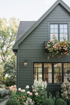 a green house with flowers in the window boxes