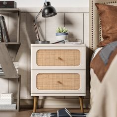 a nightstand with two drawers and a lamp next to it