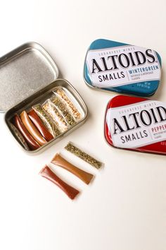 three tins of food sitting next to each other on a white counter top with spices and seasonings in them