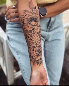 a woman with a flower tattoo on her arm and wrist is holding onto a cell phone