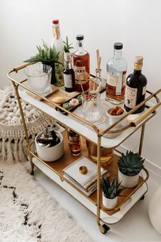 a bar cart filled with liquor bottles and drinks on top of a carpeted floor