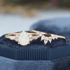 two gold rings sitting on top of a black velvet cushion with diamonds in the middle