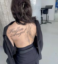 the back of a woman's body with writing on her upper and lower back