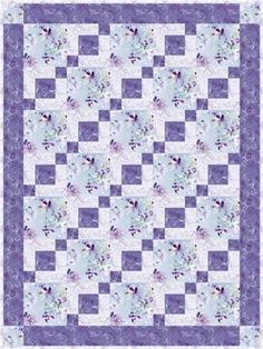 a blue and white quilt with flowers in the center, on top of a purple background