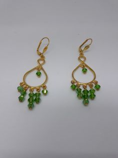 Beautiful chandelier earrings, handcrafted with quality materials and care. They measure 2 inches long and very lightweight on the ear. Made with gold tone frame, gold tone ear wire, green crystals. Great addition to any collection. Green Crystal Drop Earrings With Dangling Beads, Green Chandelier Earrings With Pierced Ears, Green Chandelier Earrings For Party, Green Teardrop Chandelier Earrings With Dangling Beads, Elegant Green Wire Wrapped Hoop Earrings, Handmade Chandelier, Beautiful Chandelier, Green Crystals, Chandelier Earrings