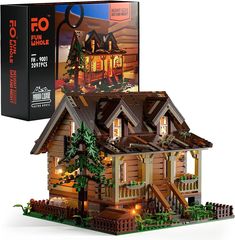 a wooden house with lights on it and a box for the model in front of it