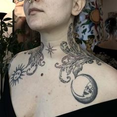 a woman with tattoos on her chest looking at the sky and stars above her head