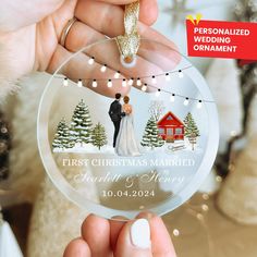 the first christmas married ornament is being held by someone