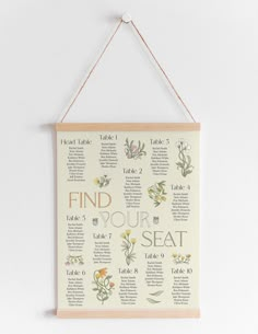 a wooden sign hanging on the wall with flowers and words written in different languages that read find your seat