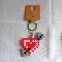 a keychain made out of legos is shown on a white sheet with a tag attached to it