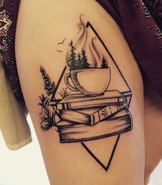 a woman's thigh with books and a cup of coffee on it