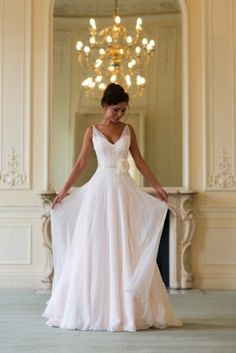 a woman in a white dress is posing for the camera