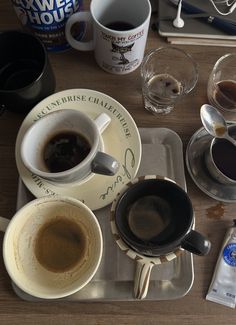 two cups of coffee are sitting on a tray next to some water and other drinks