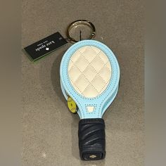 a blue and white tennis racquet shaped keychain sitting on top of a table