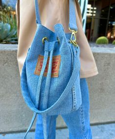 a woman carrying a blue denim purse on her shoulder