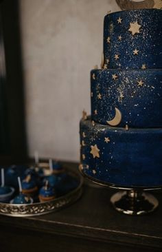 there is a blue cake with stars and moon decorations on it