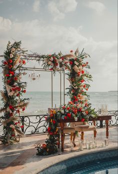 an outdoor wedding set up with flowers and greenery by the water's edge