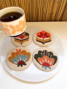 four coasters on a plate with a cup of coffee