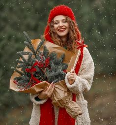 a woman holding a bouquet of flowers and wrapped in brown paper with snow falling on her