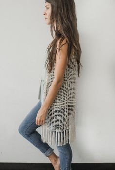 a woman standing in front of a white wall with text overlay that reads free crochet pattern for the daydreamer vest