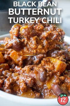 a spoon full of black bean butternut turkey chili on top of a white plate