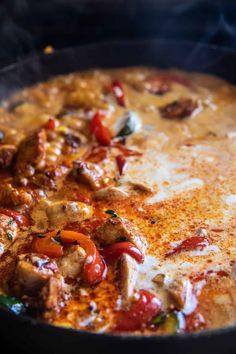 a pan filled with meat and vegetables on top of a stove