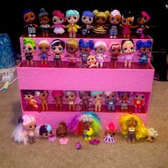 a pink shelf filled with lots of littlest pet toys on top of a carpeted floor