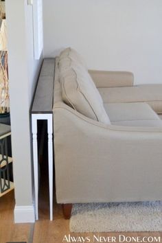 a white couch sitting next to a wooden table