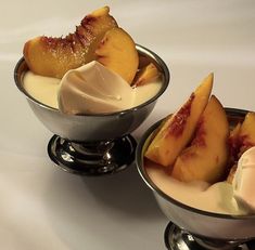 two bowls filled with ice cream and sliced peaches on top of eachother