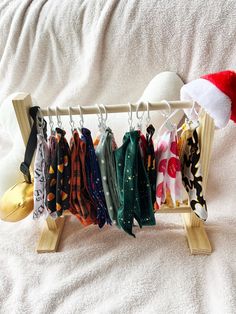 a rack with scarves and hats hanging from it's hooks on a bed