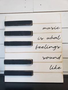 music is what feelings sound like handwritten sign on white planks with black handles