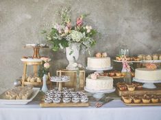 a table topped with lots of cakes and cupcakes