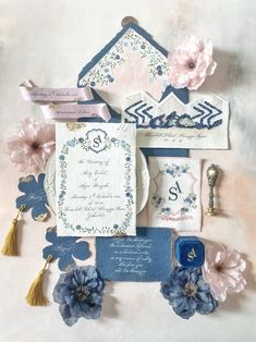 the wedding stationery is laid out on top of each other with flowers and ribbons