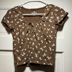 Never Worn Hollister Brown With White Flowers Short Sleeve Top Casual Brown Tops For Spring, Casual Brown Spring Tops, Brown Printed Summer Tops, Casual Brown Floral Print Tops, Brown Printed Tops For Spring, Summer Brown Tops With Floral Print, Summer Brown Floral Print Blouse, Trendy Daisy Print Tops For Summer, Casual Summer Top With Daisy Print