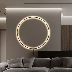 a living room filled with furniture and a large circular light on the wall above it