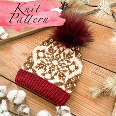 a red and white knitted hat sitting on top of a wooden floor next to cotton balls