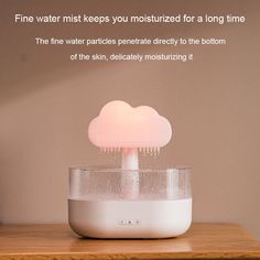 a white cloud lamp sitting on top of a wooden table next to a bottle of water