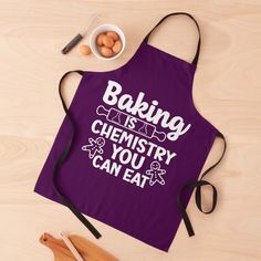 a purple apron that says baking is chemistry you can eat on it next to eggs and utensils