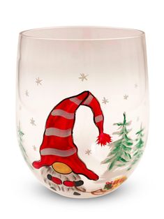 a wine glass with an image of a gnome in the snow and christmas trees on it