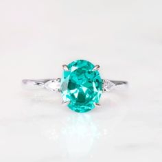 Gorgeous Paraiba Tourmaline Ring ►Made of solid sterling silver with rhodium finish (925) ►Accented With Simulated Diamonds (CZ) ►Average band width: 2 mm Center Stone: Paraiba Tourmaline Color: Turquoise Shape: Oval Measurements: 7.0 x 9.0 mm Carat Weight: 1.8 ct. (approx.) Gemstone creation: lab-grown Hardness: 7-7.5 (Mohs scale) ✓ 100% Nickel-Free ✓ Hypoallergenic ✓ Comfort Fit ✓ Free Ring Box ✓ Free USA Shipping Oval Turquoise Topaz Ring With Accent Stones, Elegant Oval Turquoise Topaz Ring With Accent Stones, Turquoise Emerald Ring For Anniversary, Turquoise Birthstone Ring With Accent Stones For Anniversary, Green Topaz Sterling Silver Ring For Wedding, Green Topaz Sterling Silver Wedding Ring, Green Topaz Wedding Ring In Sterling Silver, Turquoise Topaz Ring With Accent Stones For Anniversary, Anniversary Turquoise Topaz Ring With Accent Stones