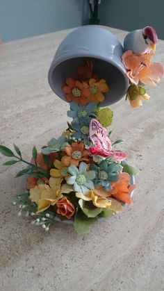 there is a vase with flowers in it sitting on the counter top next to a bird figurine