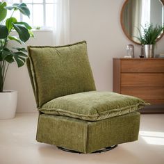 a green chair sitting on top of a white floor next to a potted plant