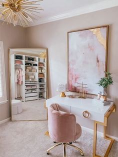 a pink chair sits in front of a white desk with a gold framed mirror on it