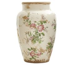 a white vase with pink and green flowers painted on the front, sitting against a white background