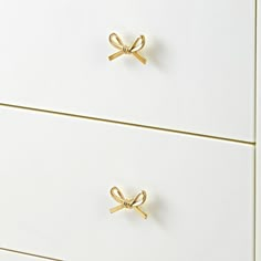 a white dresser with two gold handles on it