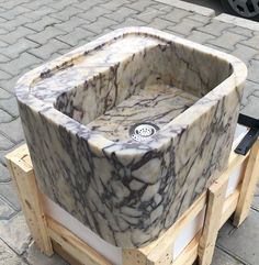 a marble sink sitting on top of wooden pallets